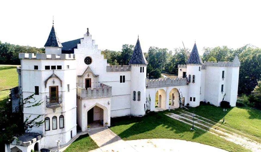 Aerial view of Chateau Charmant, its white turrets and battlements above green lawns